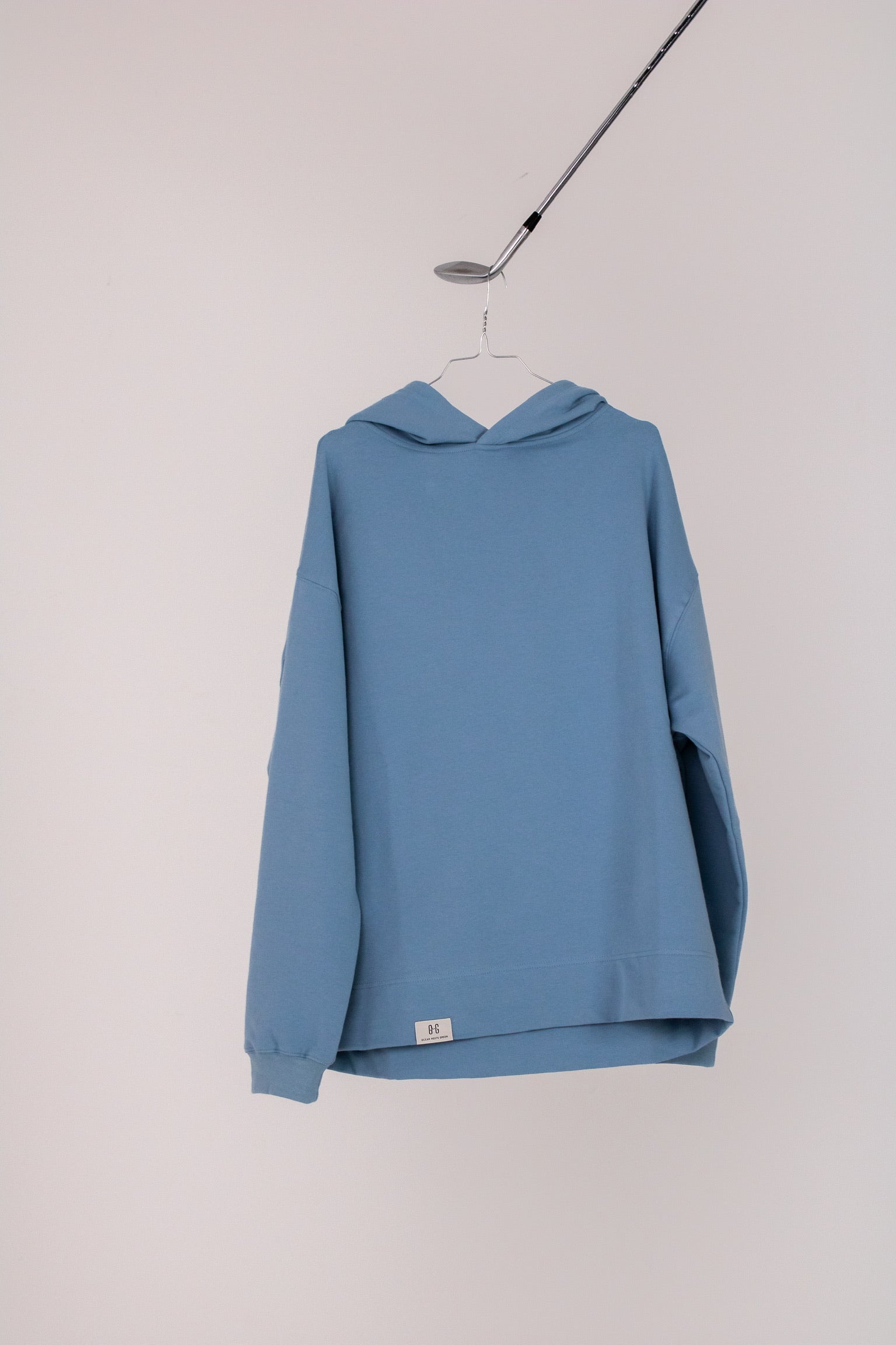 Image of Ocean Meets Green men's golf hoodie Wave in ice on a hanger