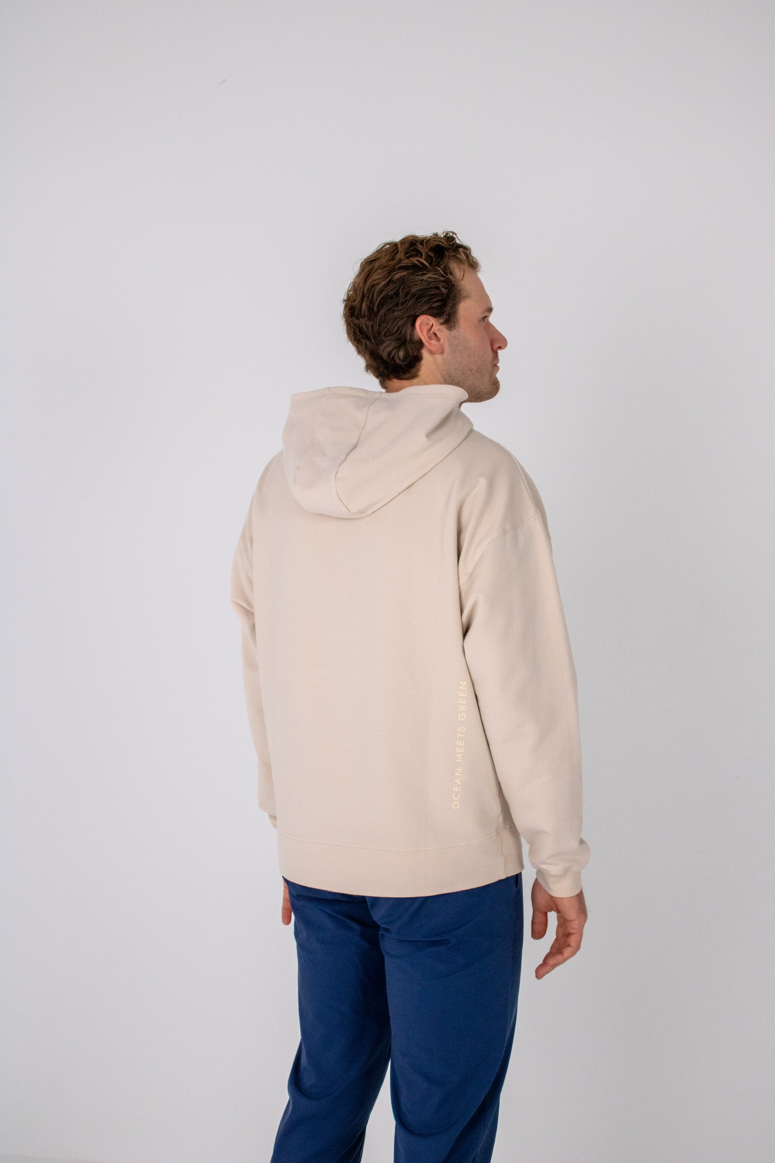 Full body image of Ocean Meets Green men's golf hoodie Wave in sand, showing the back