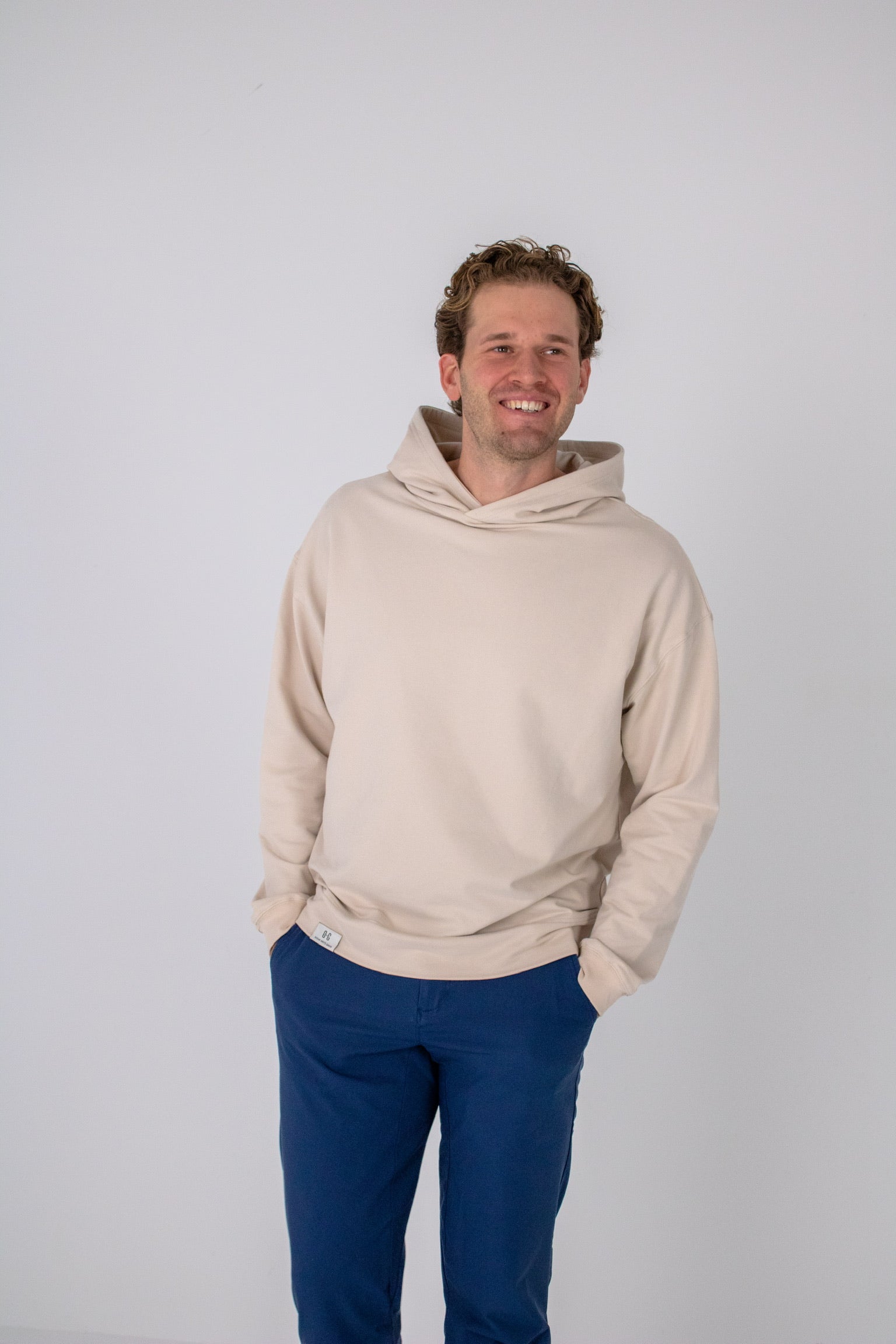 Full body image of Ocean Meets Green men's golf hoodie Wave in sand