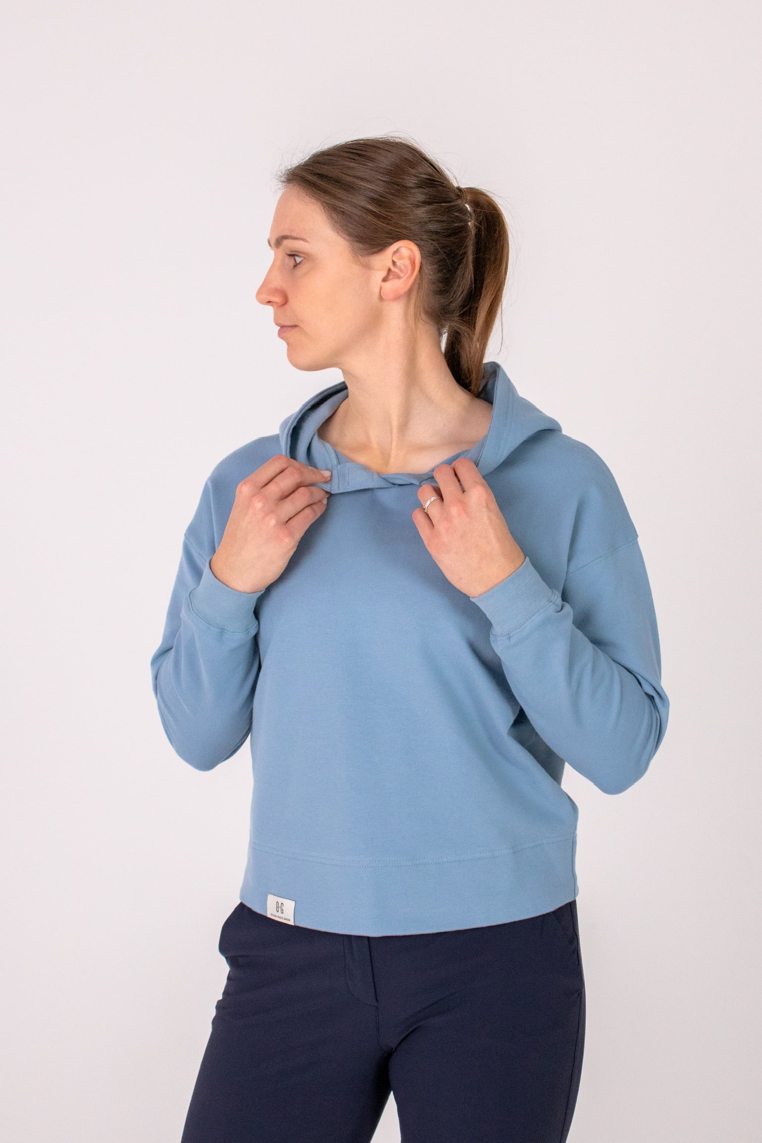 Fullbody image of Ocean Meets Green women's golf hoodie Flow in ice, showing the front opening
