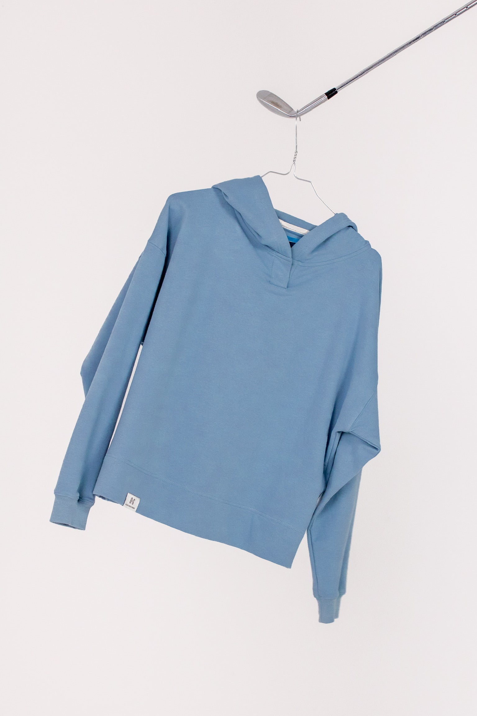 Image of Ocean Meets Green women's golf hoodie Flow in ice on a hanger