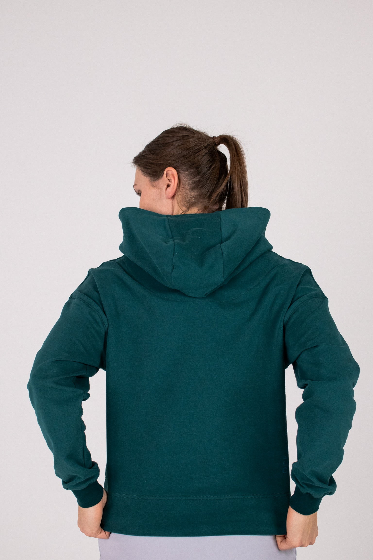 Fullbody image of Ocean Meets Green women's golf hoodie Flow in pine, showing the back