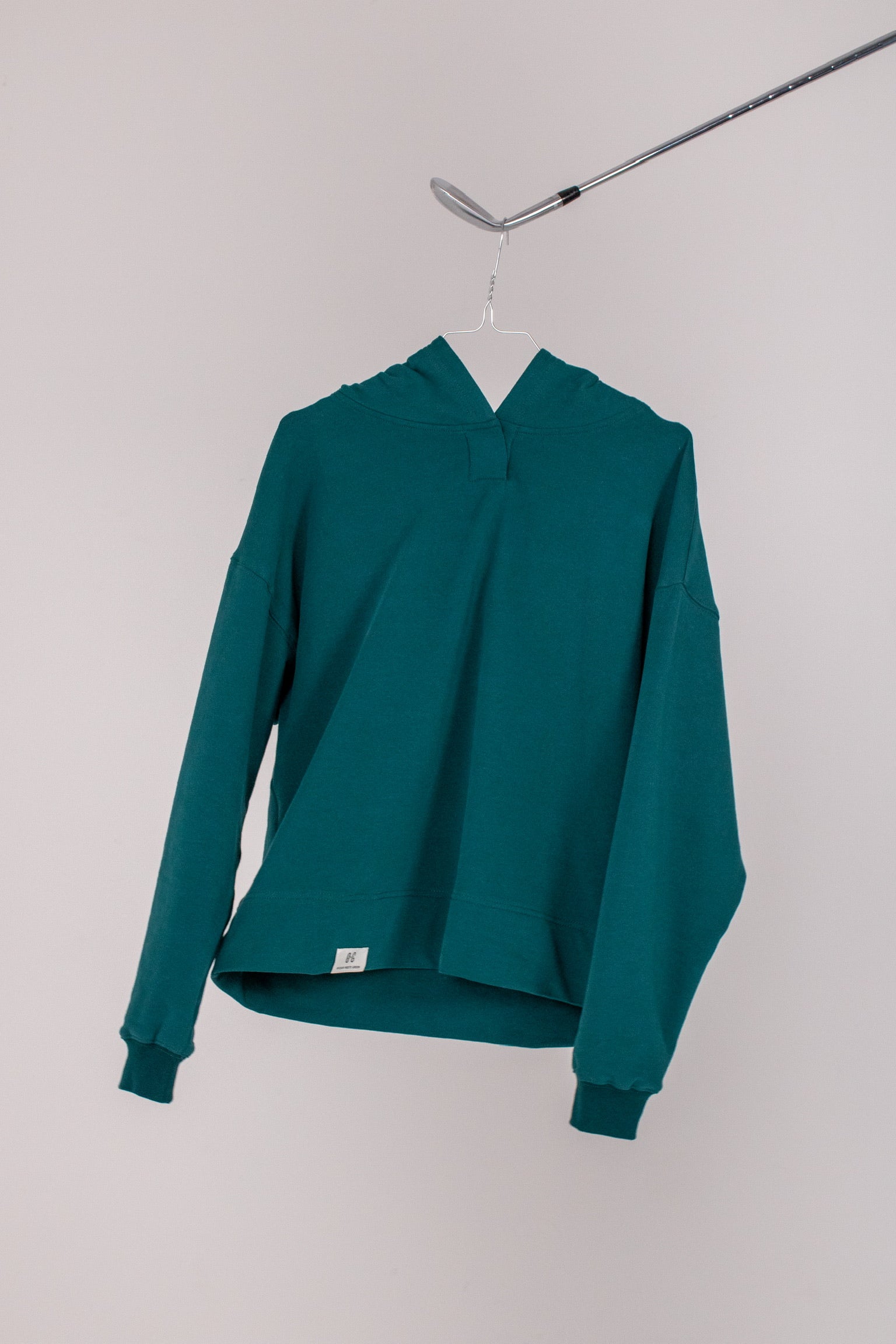 Image of Ocean Meets Green women's golf hoodie Flow in pine on a hanger