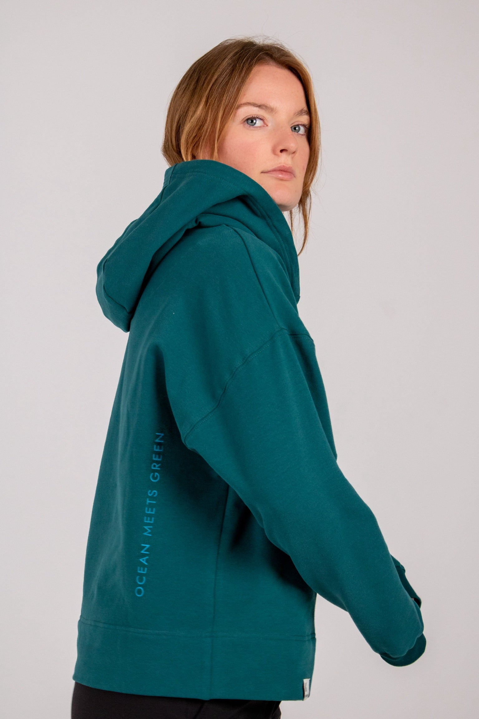 Fullbody image of Ocean Meets Green women's golf hoodie Flow in pine, oversized look