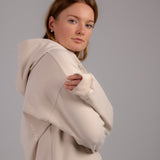 Fullbody image of Ocean Meets Green women's golf hoodie Flow in sand, cozy look