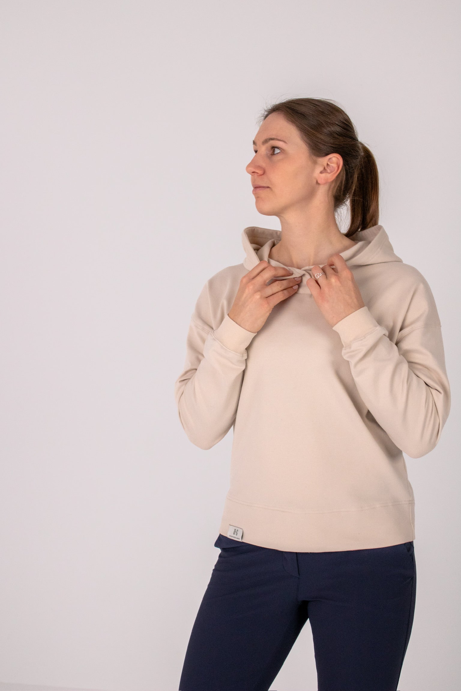 Fullbody image of Ocean Meets Green women's golf hoodie Flow in sand