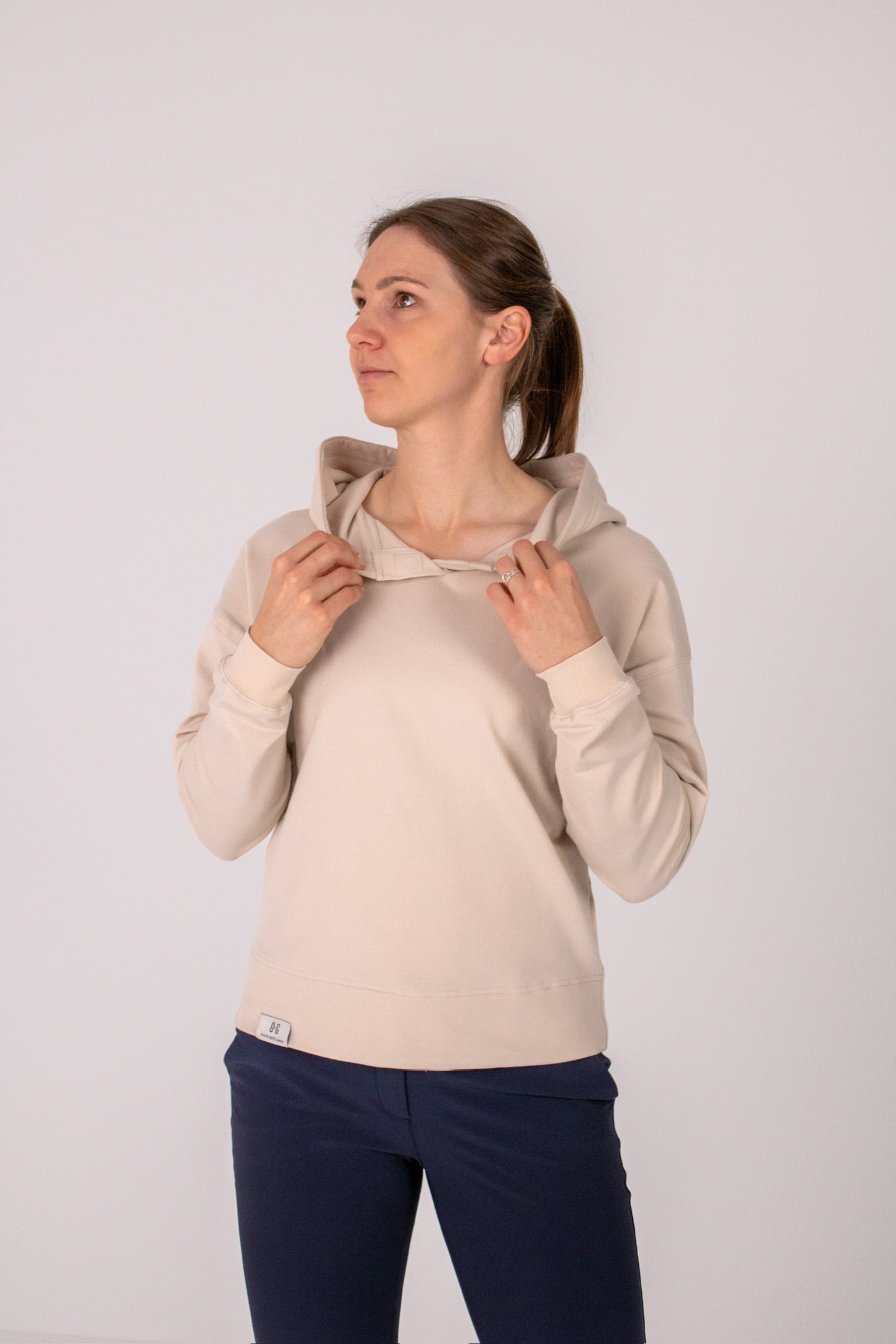 Fullbody image of Ocean Meets Green women's golf hoodie Flow in sand