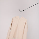Image of Ocean Meets Green women's golf hoodie Flow in sand on a hanger
