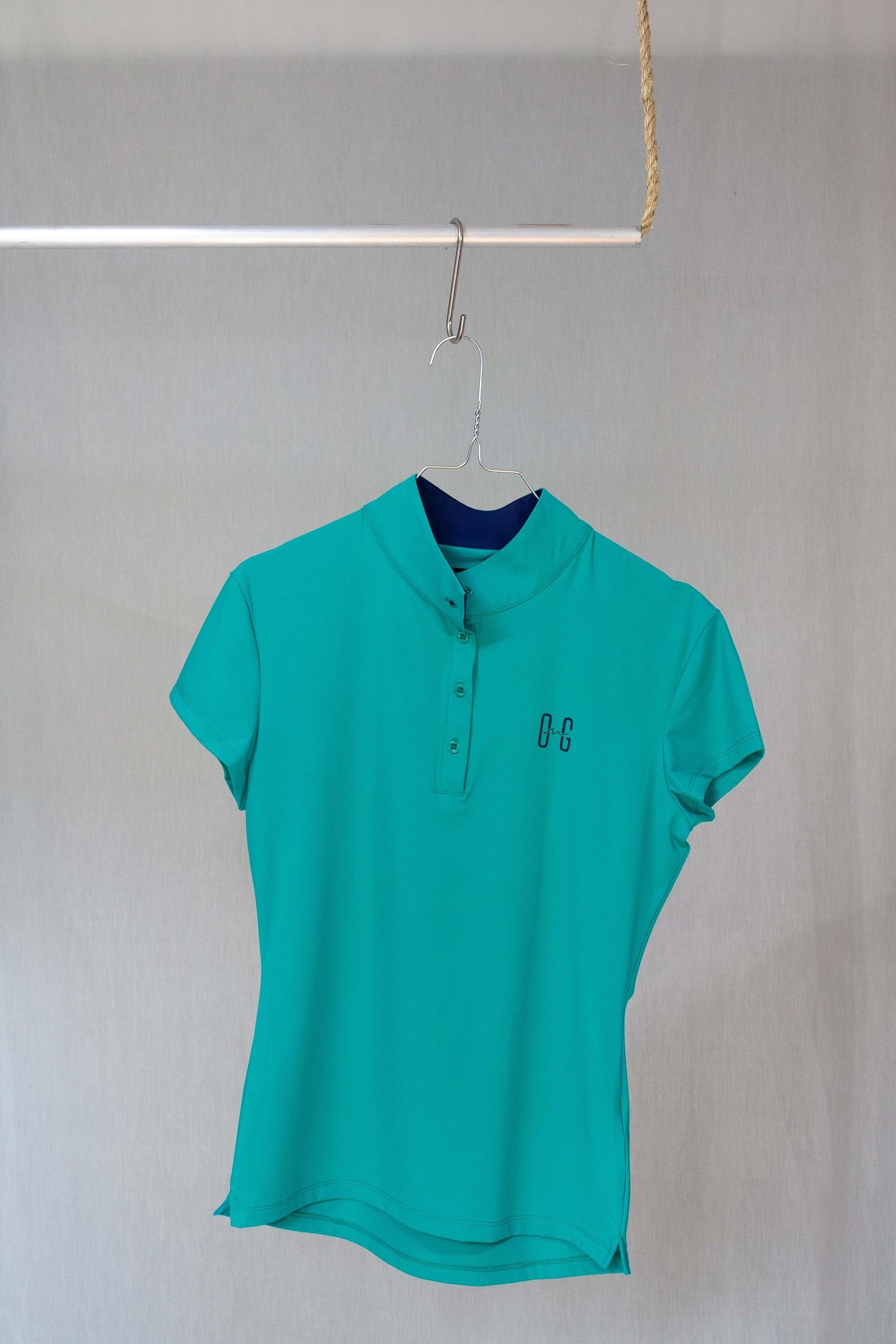 Image of Ocean Meets Green women's golf polo Moana in green on a hanger front view