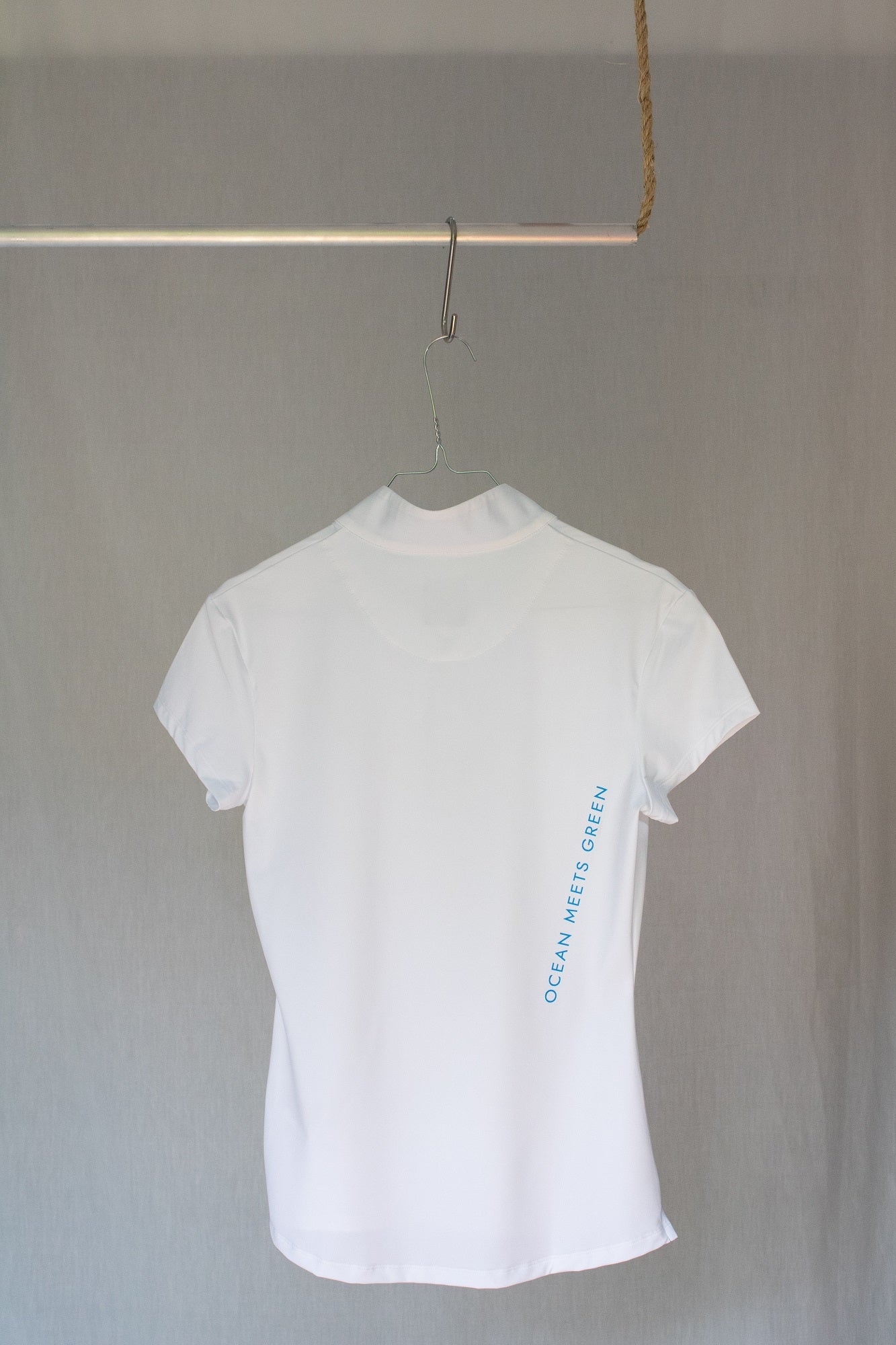 Image of Ocean Meets Green women's golf polo Moana in white on a hanger back view