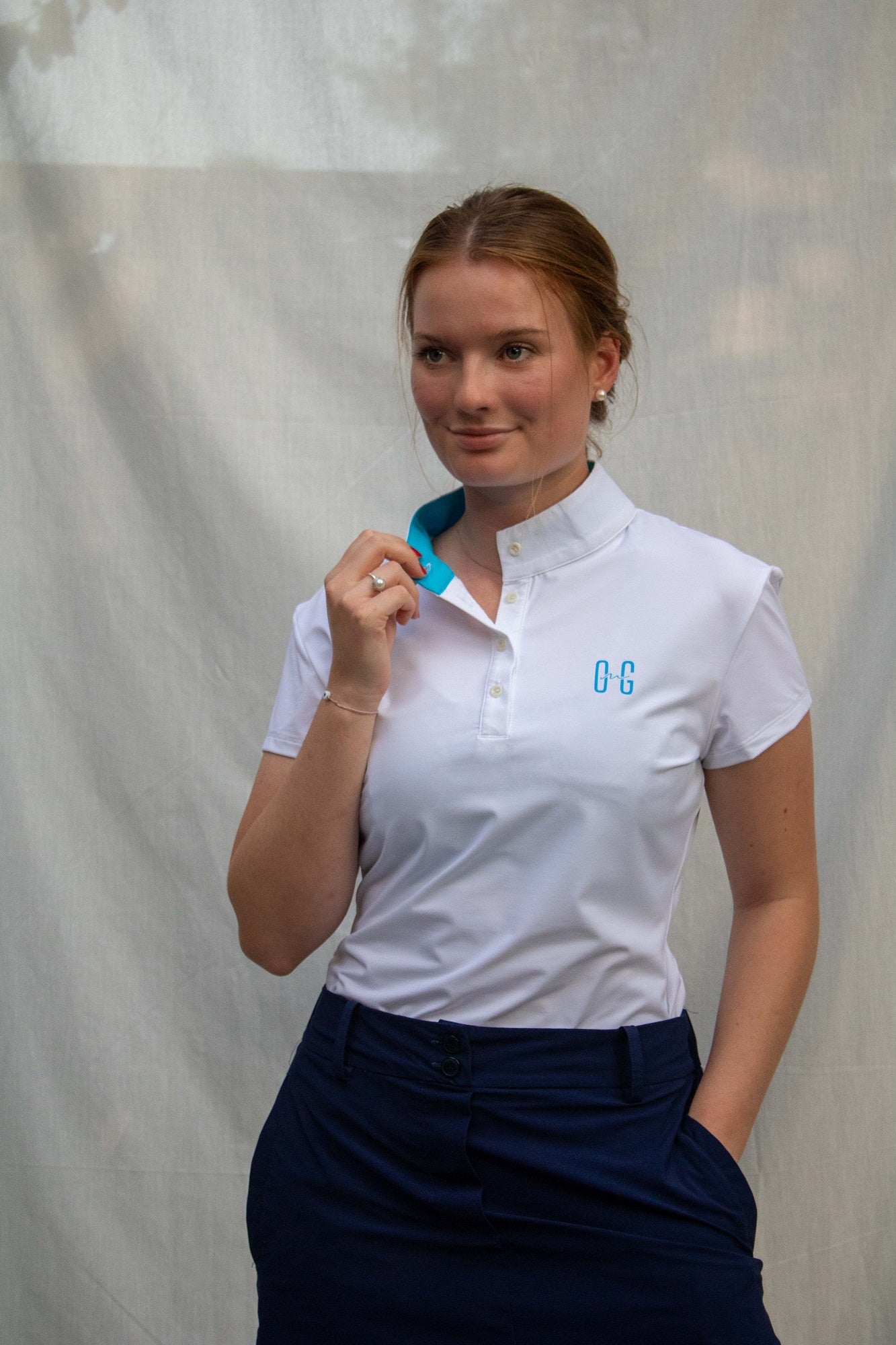 Full body image of Ocean Meets Green women's golf polo Moana in white worn by a woman