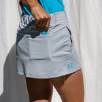 Full body image of Ocean Meets Green women's golf skirt Tide in grey, showing the back pocket