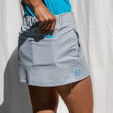 Full body image of Ocean Meets Green women's golf skirt Tide in grey, showing the back pocket