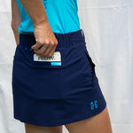 Full body image of Ocean Meets Green women's golf skirt Tide in navy, showing the back pocket