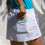 Full body image of Ocean Meets Green women's golf skirt Tide in white, showing the back pocket
