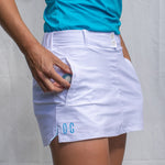 Full body image of Ocean Meets Green women's golf skirt Tide in white, showing the side pocket