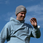 Ocean Meets Green Cloud beanie in grey, made from merino wool, worn by a male golfer