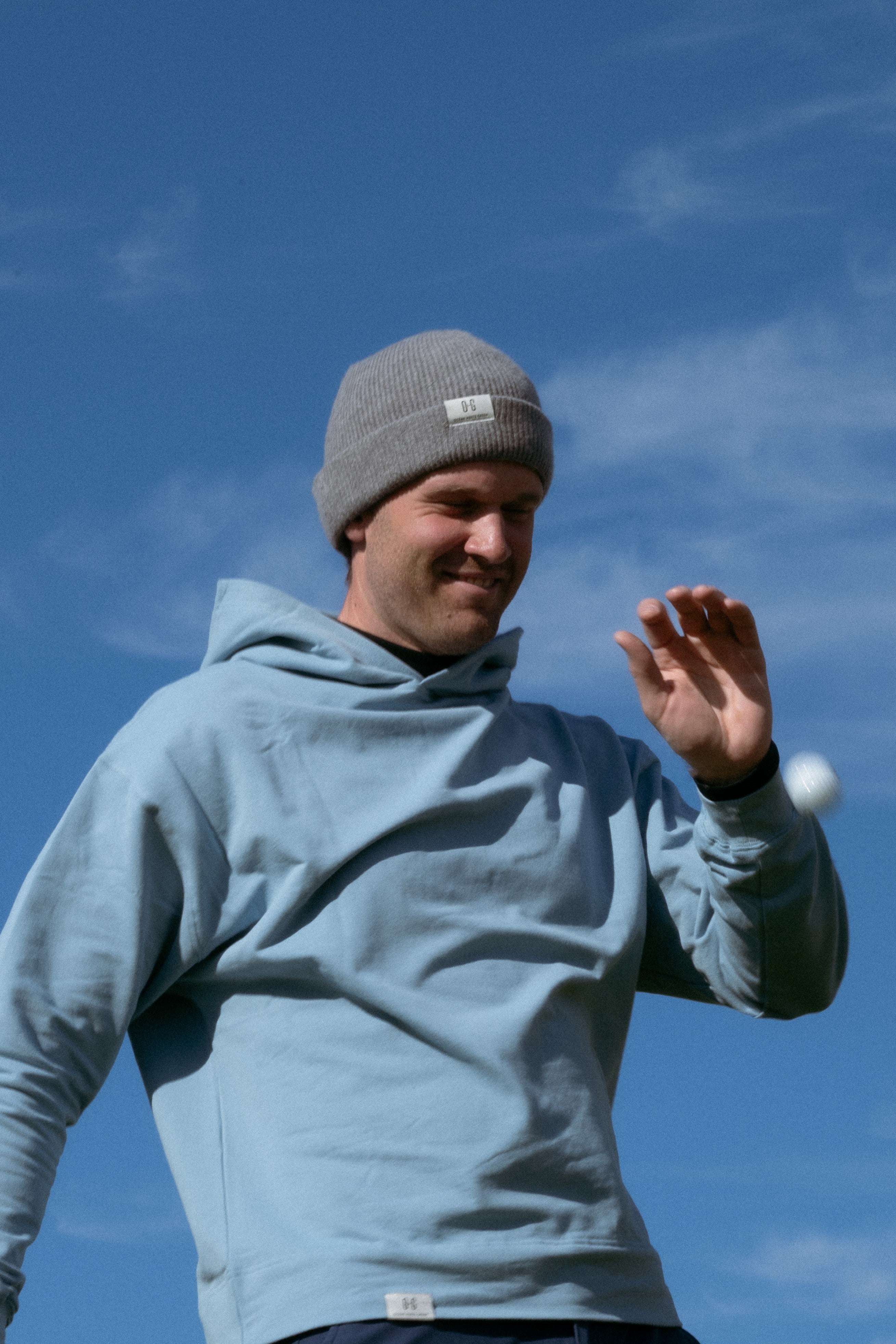 Ocean Meets Green Cloud beanie in grey, made from merino wool, worn by a male golfer