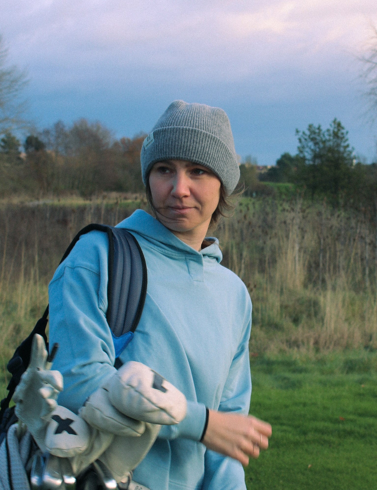 Ocean Meets Green Cloud beanie in grey, fine rib, made from merino wool, worn by a female golfer