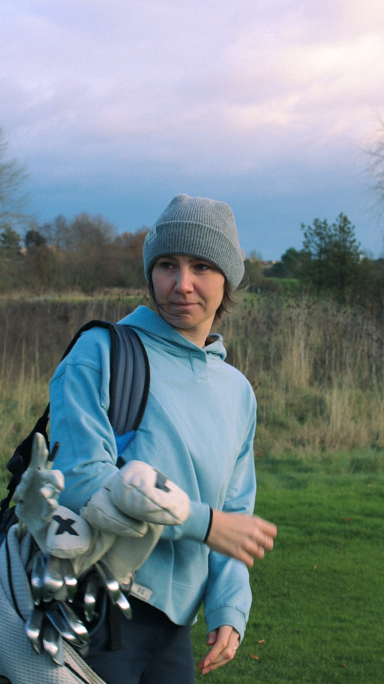 Ocean Meets Green Cloud beanie in grey, fine rib, made from merino wool, worn by a female golfer