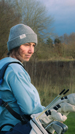 Ocean Meets Green Cloud beanie in grey, fine rib, made from merino wool, worn by a female golfer