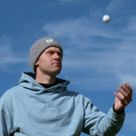 Ocean Meets Green Cloud beanie in grey, made from merino wool, worn by a male golfer