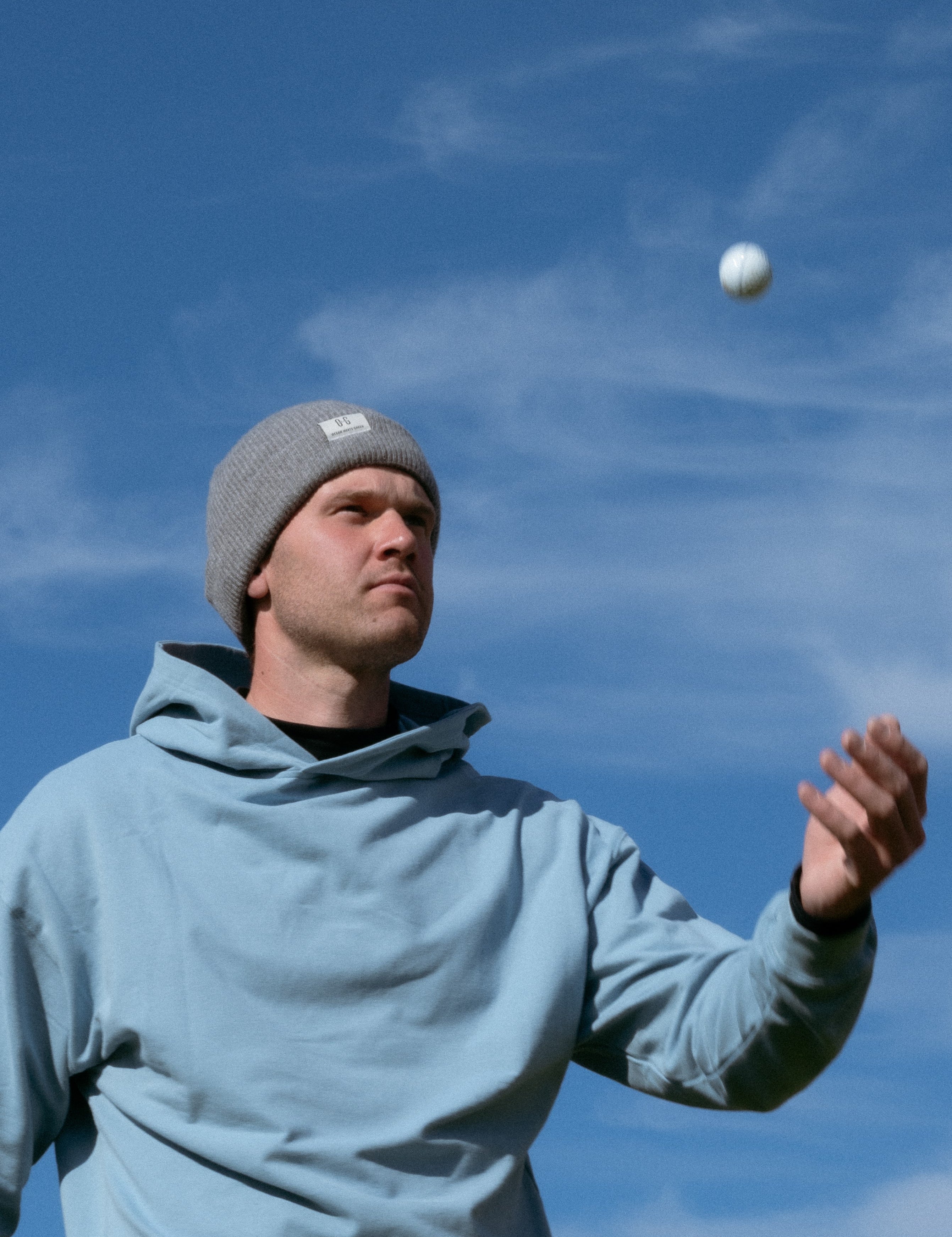 Ocean Meets Green Cloud beanie in grey, made from merino wool, worn by a male golfer