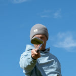 Ocean Meets Green Cloud beanie in grey, made from merino wool, worn by a male golfer pointing a club