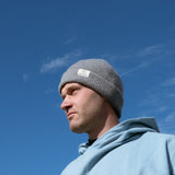 Ocean Meets Green Cloud beanie in grey, made from merino wool, worn by a male golfer