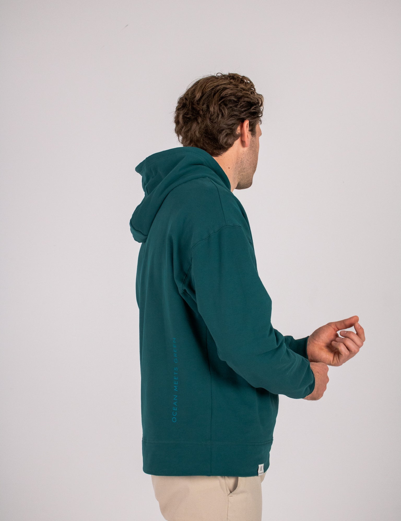 Full body image of Ocean Meets Green men's golf hoodie Wave in pine, showing the logo