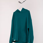 Image of Ocean Meets Green men's golf hoodie Wave in pine on a hanger