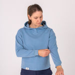 Fullbody image of Ocean Meets Green women's golf hoodie Flow in ice, pulling sleeve up