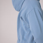 Image of Ocean Meets Green women's golf hoodie Flow in ice, showing the logo