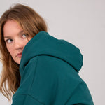 Closeup image of Ocean Meets Green women's golf hoodie Flow in pine, oversized and cozy look