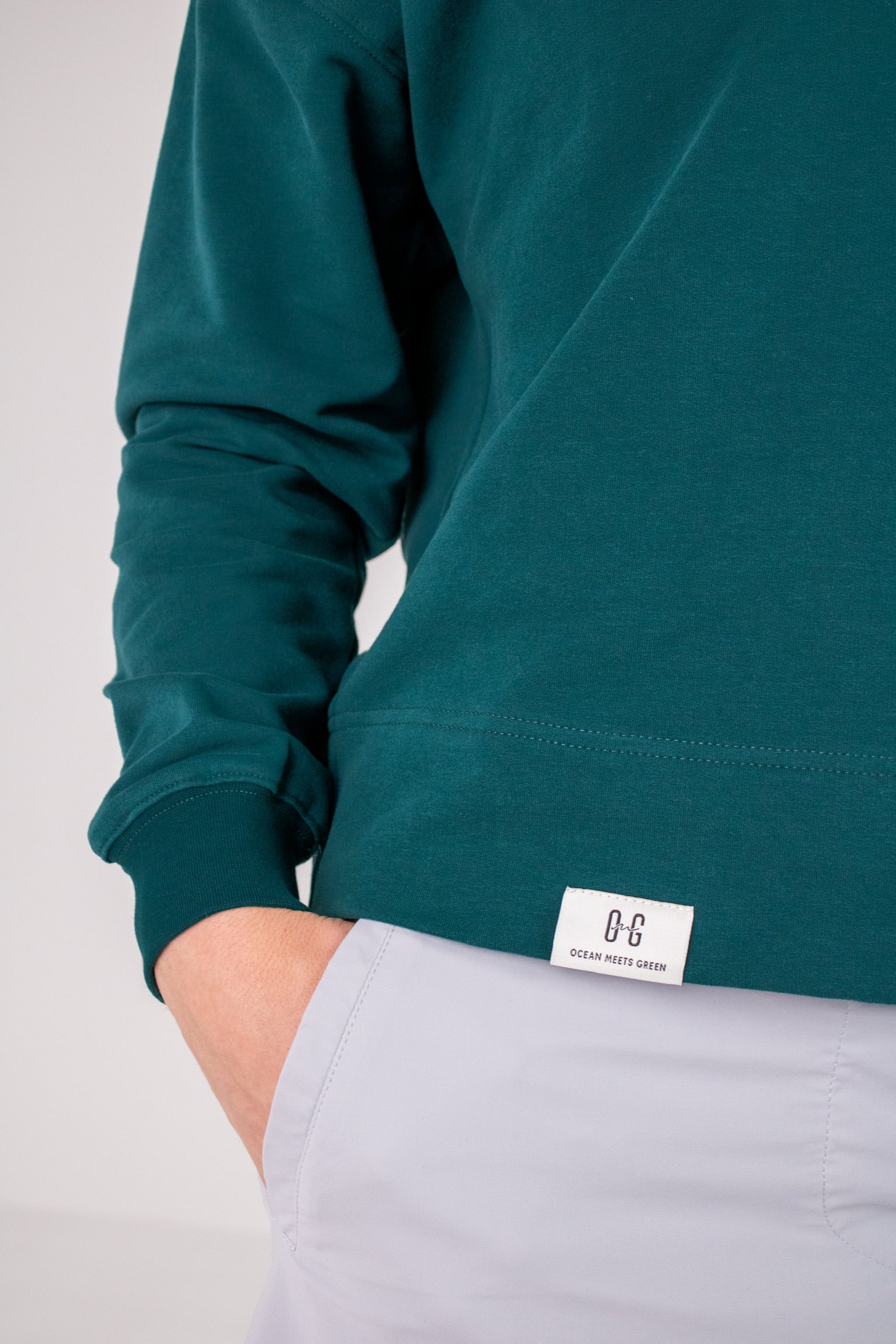 Closeup image of label on Ocean Meets Green women's golf hoodie Flow in pine