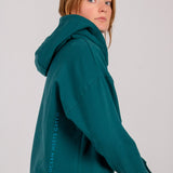 Fullbody image of Ocean Meets Green women's golf hoodie Flow in pine, oversized look