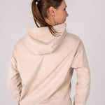 Fullbody image of Ocean Meets Green women's golf hoodie Flow in sand, showing the back