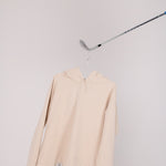 Image of Ocean Meets Green women's golf hoodie Flow in sand on a hanger