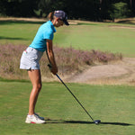 Image of female golfer wearing the Ocean Meets Green TIDE skirt in grey and the MOANA poloshirt in light blue