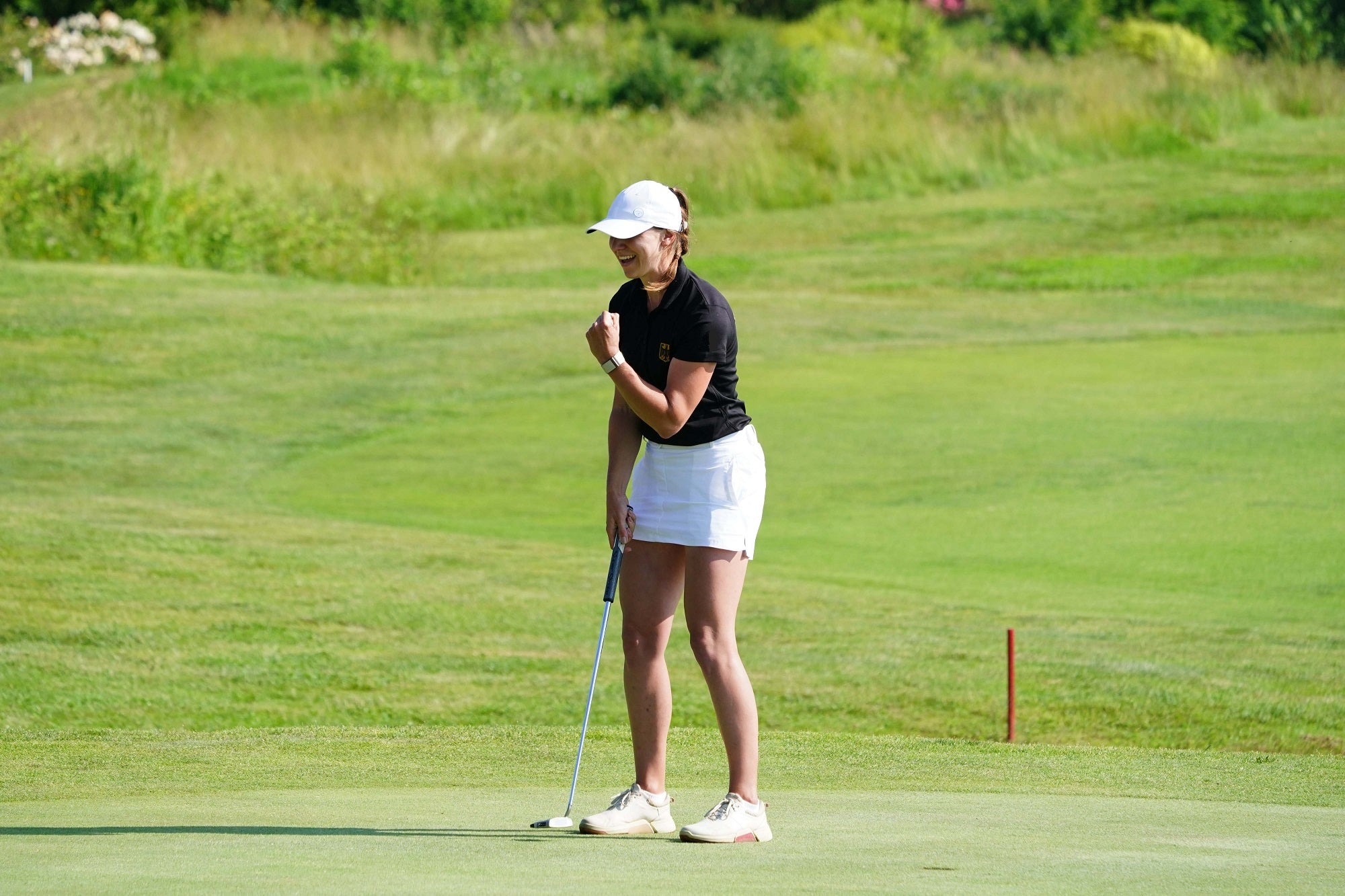 Image of woman wearing Ocean Meets Green Tide skirt in white at the 2023 European Mid-Amateur Championship