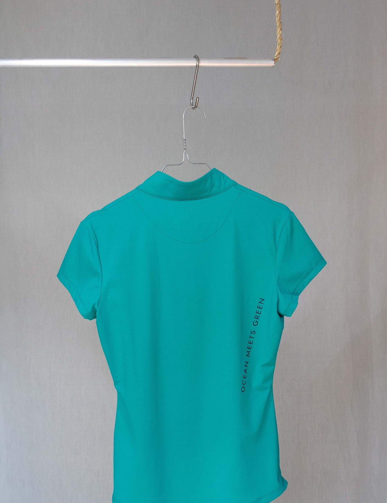 Image of Ocean Meets Green women's golf polo Moana in green on a hanger back view