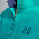 Image of Ocean Meets Green women's golf polo Moana in green, showing the standup collar and front logo