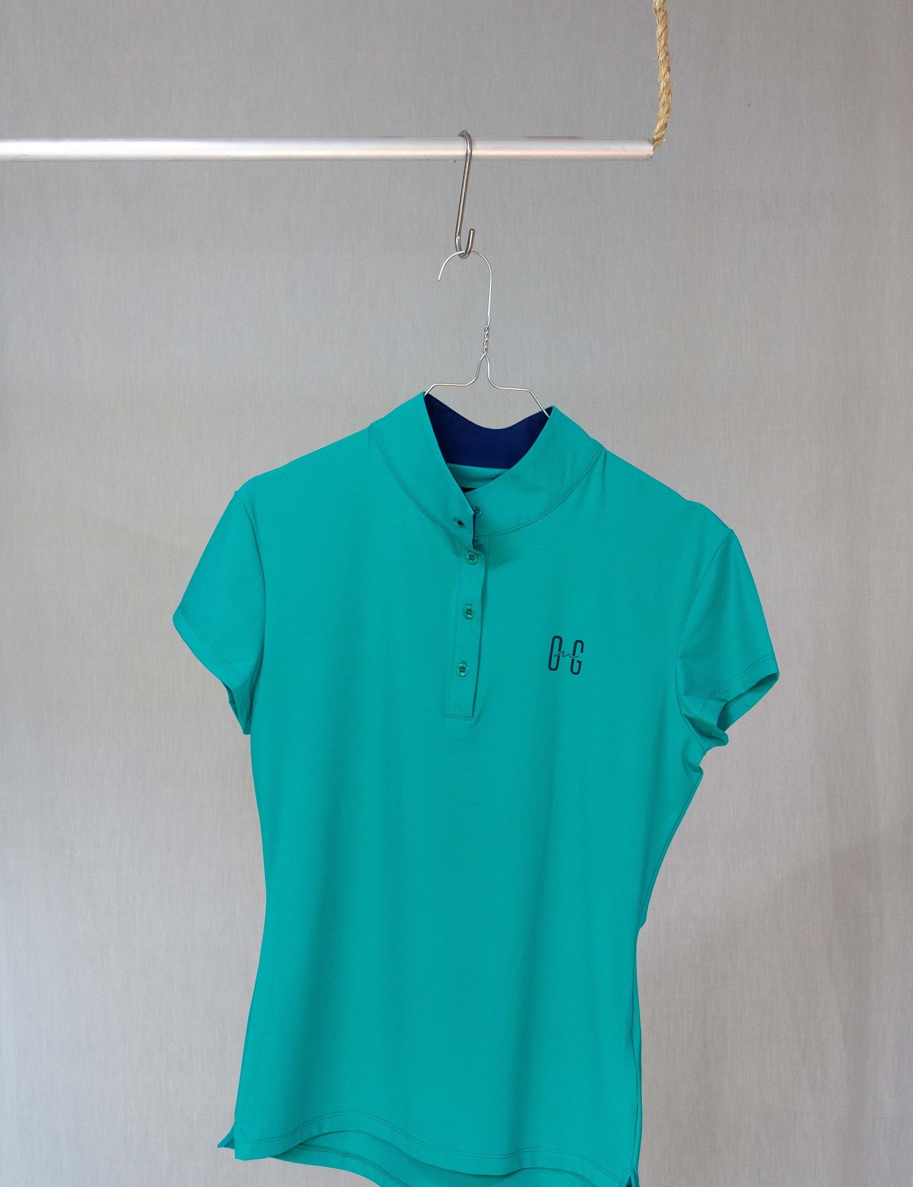 Image of Ocean Meets Green women's golf polo Moana in green on a hanger front view