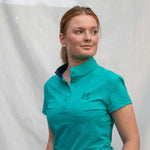 Full body image of Ocean Meets Green women's golf polo Moana in green worn by a woman