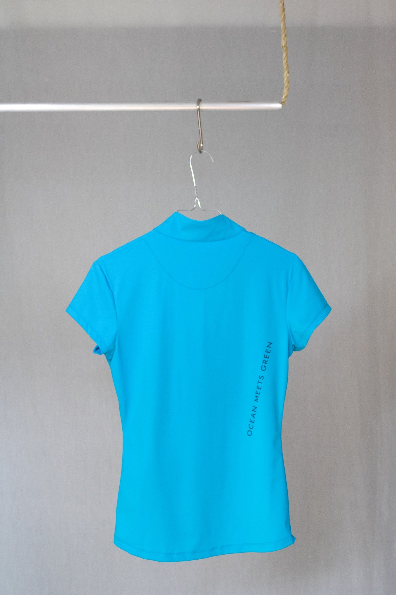 Image of Ocean Meets Green women's golf polo Moana in light blue on a hanger back view