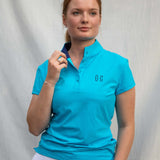 Full body image of Ocean Meets Green women's golf polo Moana in light blue worn by a woman