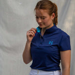 Full body image of Ocean Meets Green women's golf polo Moana in navy worn by a woman