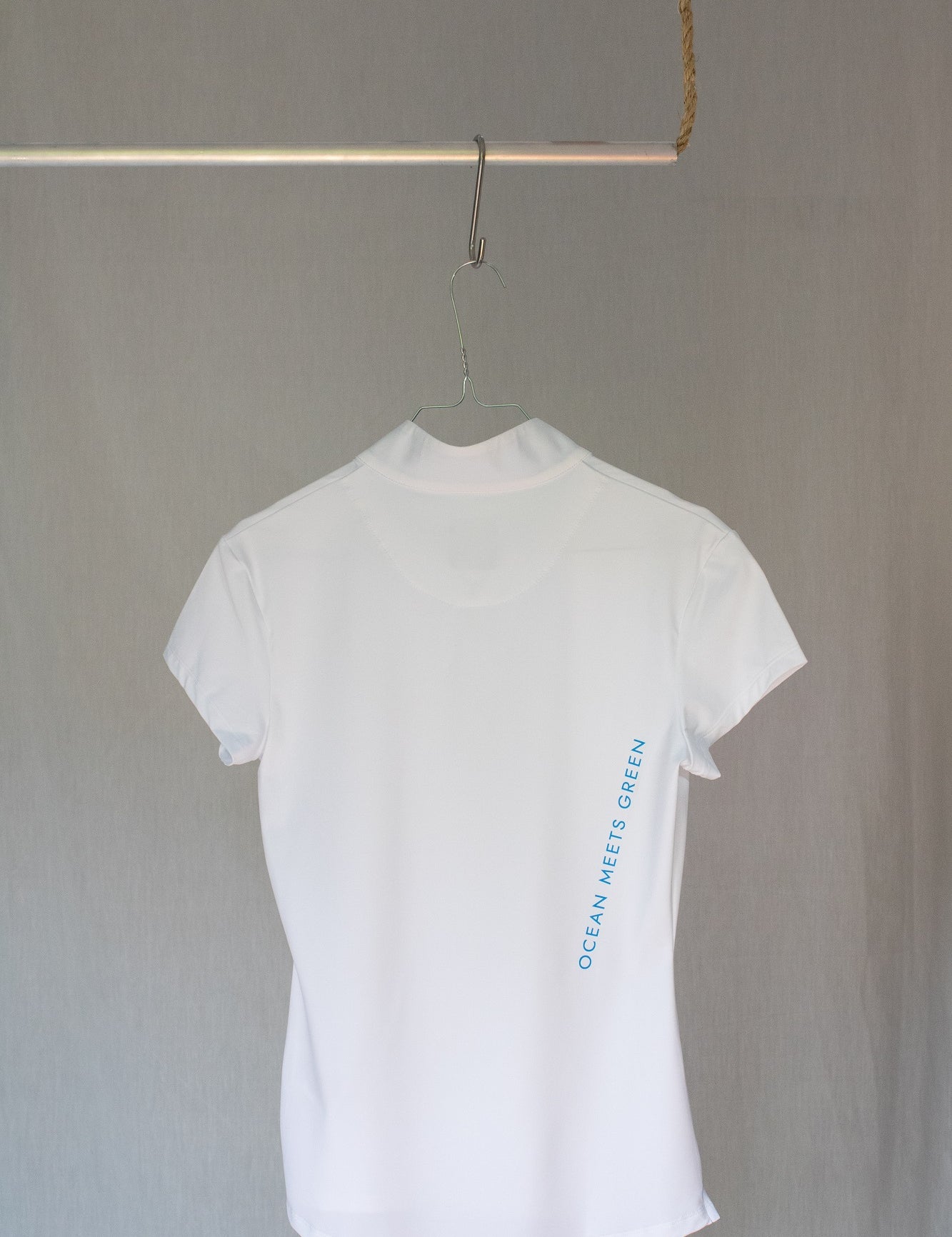 Image of Ocean Meets Green women's golf polo Moana in white on a hanger back view