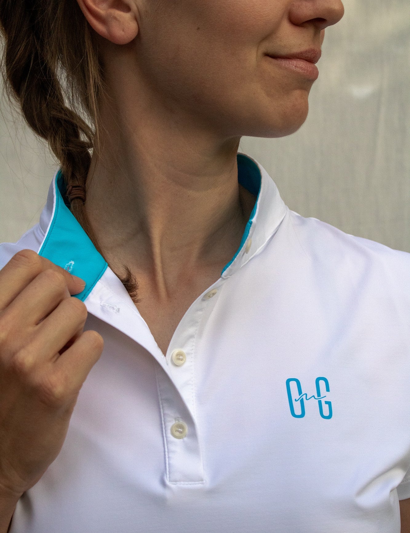 Image of Ocean Meets Green women's golf polo Moana in white, showing the standup collar and front logo