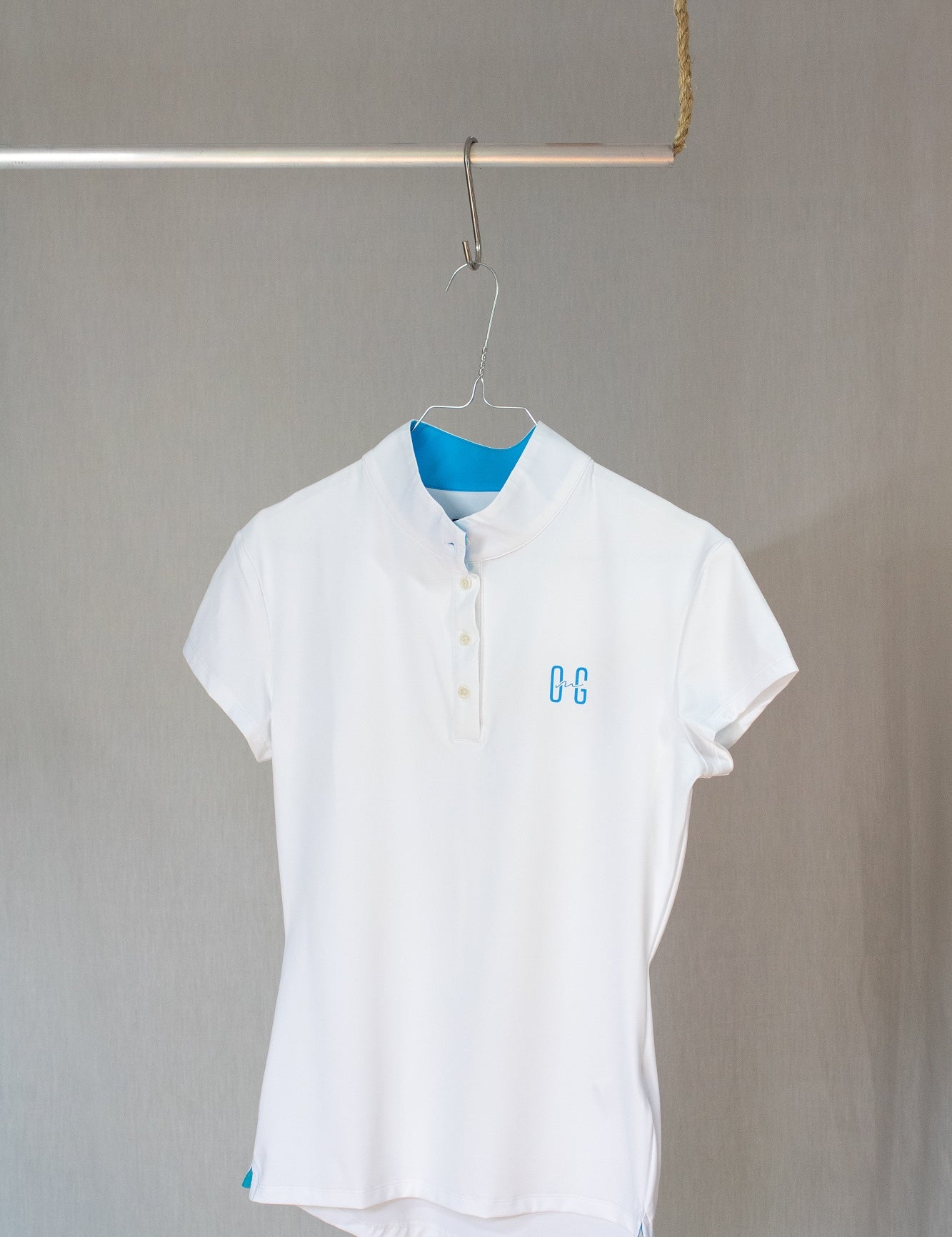 Image of Ocean Meets Green women's golf polo Moana in white on a hanger front view